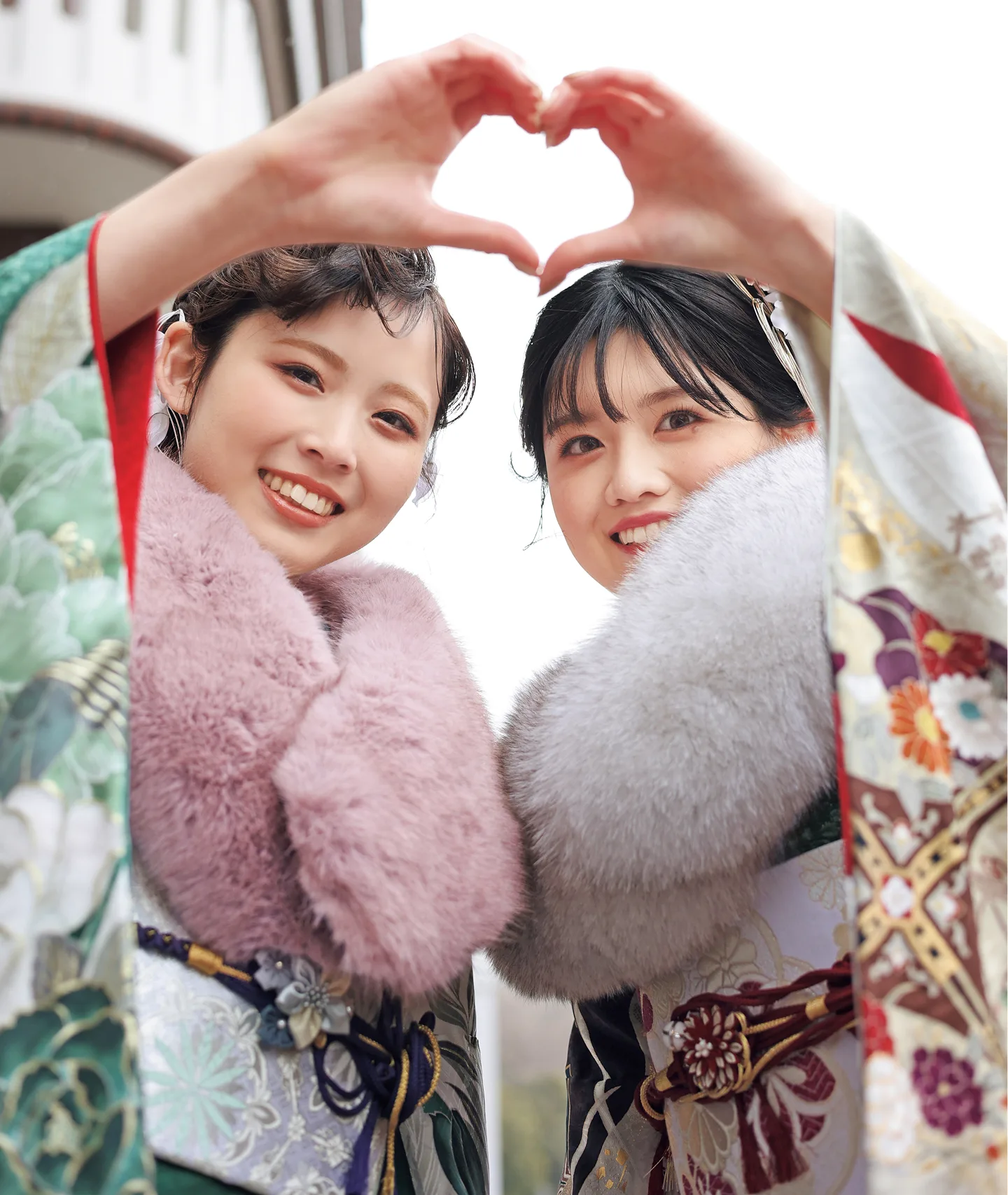 ハートを作る振袖姿の2人の女性